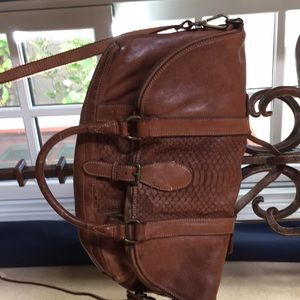 Versatile leather bag finished with brass fittings. Zipper closure. Free People